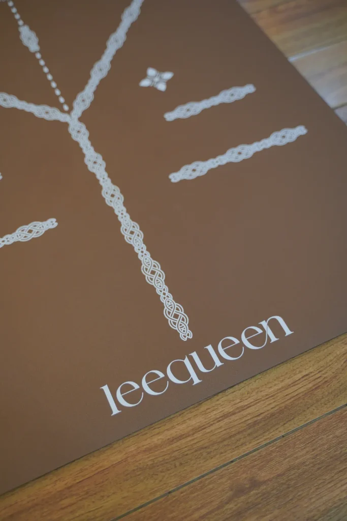 Cận cảnh mặt thảm Leequeen màu nâu với logo và đường định tuyến màu sáng