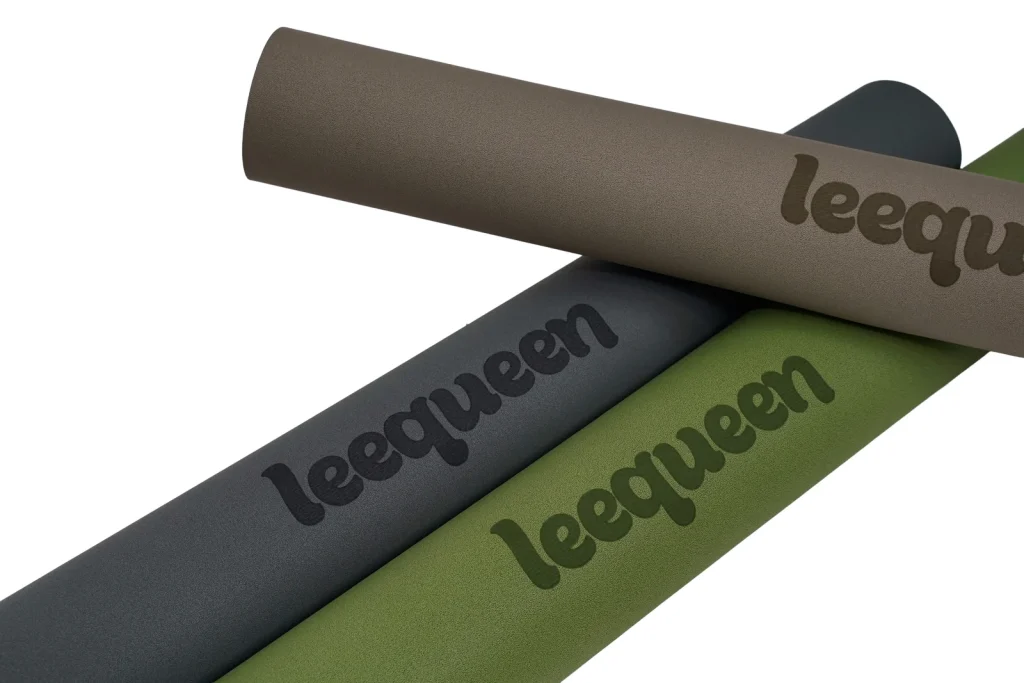 Các thảm Leequeen màu be, xám và xanh với bề mặt logo được chụp cận cảnh